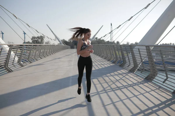 Femme active coureuse jogging à travers le pont, course en plein air, sport et mode de vie sain concept . — Photo