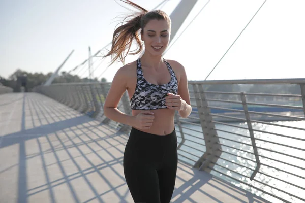 Corredor mulher ativa correndo através da ponte, ao ar livre correndo, esporte e conceito de estilo de vida saudável . — Fotografia de Stock