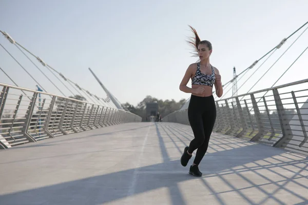 Aktive Läuferin joggt über Brücke, Outdoor-Laufen, Sport und gesundes Lebensstilkonzept. — Stockfoto