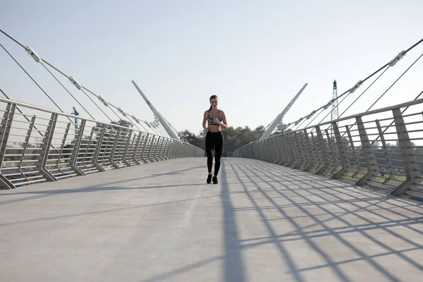 活跃的妇女赛跑者跨桥梁, 户外奔跑, 体育和健康生活方式概念的慢跑. — 图库照片