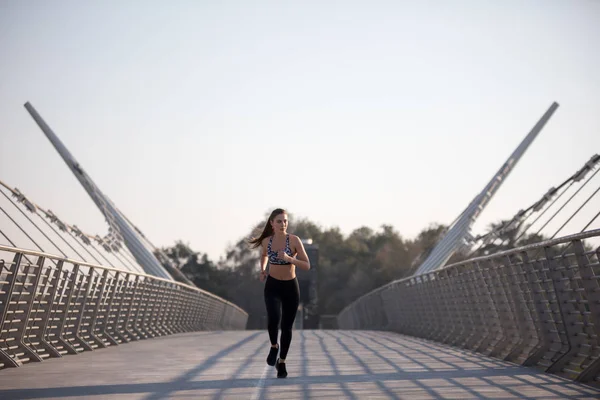 Kobiety aktywne biegacza jogging przez most, na zewnątrz działa, sport i pojęcie zdrowego stylu życia. — Zdjęcie stockowe