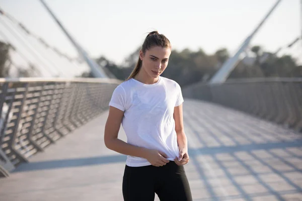 Sportlerin im weißen T-Shirt beim Training auf der Brücke. Attrappe. — Stockfoto