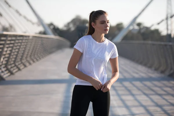 运动妇女穿着白色 t恤, 而在桥上训练。模拟. — 图库照片