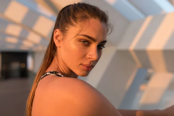 Close-up portret van mooie vrouw in het zonlicht bij zonsondergang. — Stockfoto