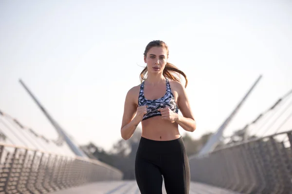 Aktive Läuferin joggt über Brücke, Outdoor-Laufen, Sport und gesundes Lebensstilkonzept. — Stockfoto