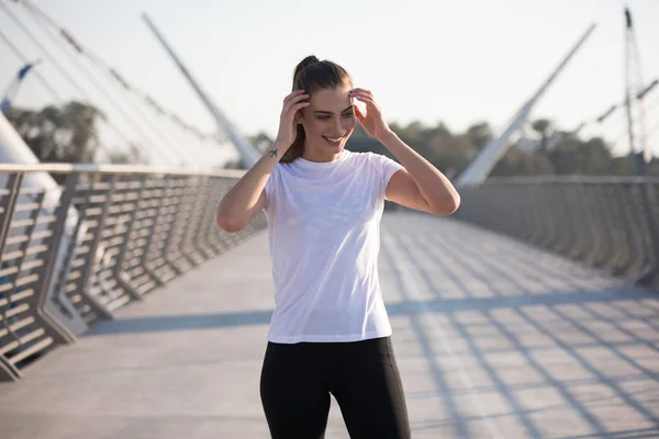 Sportlerin im weißen T-Shirt beim Training auf der Brücke. Attrappe. — Stockfoto