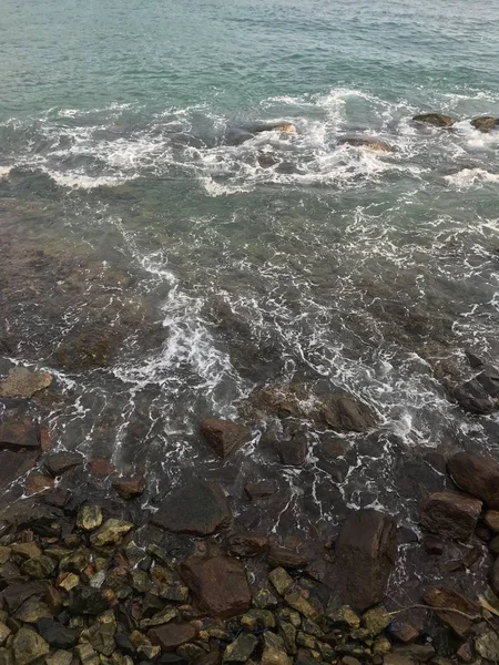 Les vagues de l'océan sont baignées par un rivage pierreux . — Photo