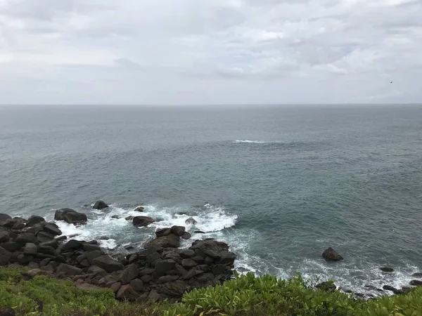 Хвилі океану омиваються кам'янистим берегом . — стокове фото