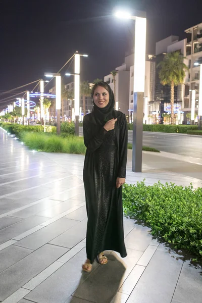 イスラム教徒の女性はヒジャーブを着て夜の街の散歩します。. — ストック写真