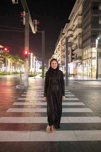 Muslimische Frau überquert nachts die Straße. — Stockfoto