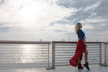 Deniz arka plan üzerinde Kırmızı elbiseli güzel kadın.