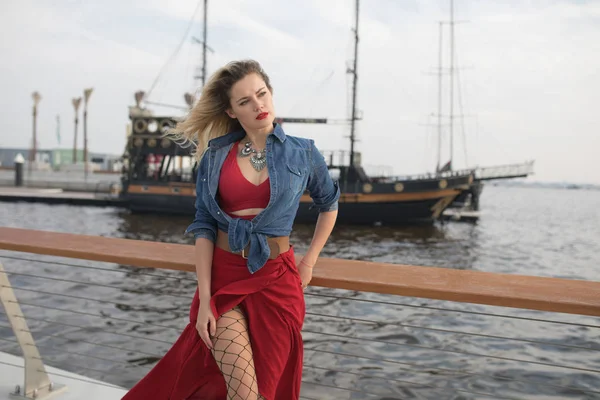 Wanita cantik dengan gaun merah dengan latar belakang kapal . — Stok Foto