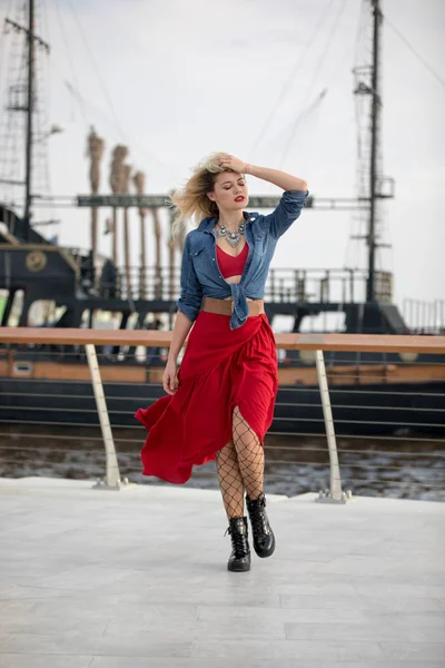 Wanita cantik dengan gaun merah dengan latar belakang kapal . — Stok Foto