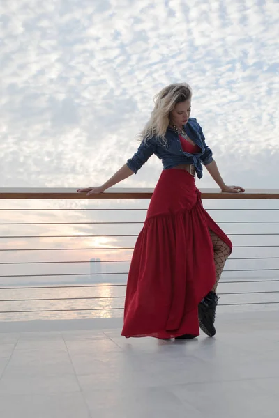 Deniz arka plan üzerinde Kırmızı elbiseli güzel kadın. — Stok fotoğraf