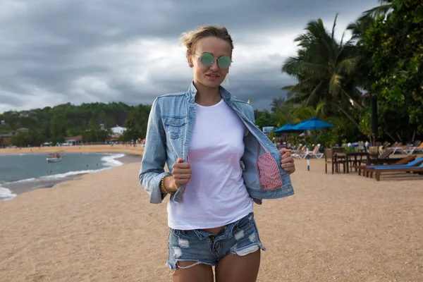 美丽的年轻女子穿着白色 t恤在海滩上。模拟. — 图库照片