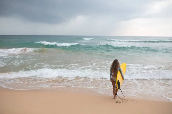 Surfer Girl innehar en styrelse och går in i havet. — Stockfoto