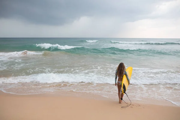 Surfer Girl innehar en styrelse och går in i havet. — Stockfoto
