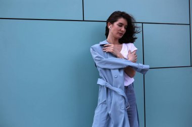 Turkuaz bir arka plan üzerinde çekici genç kadın.