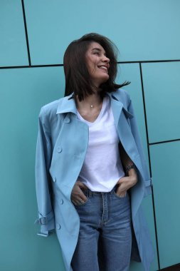 Turkuaz bir arka plan üzerinde çekici genç kadın.