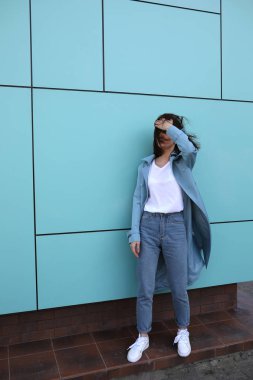 Turkuaz bir arka plan üzerinde çekici genç kadın.