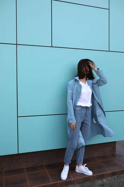 Attractive young woman on a turquoise background. — Stock Photo, Image