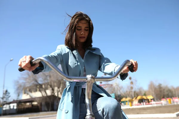 Stylish young woman riding a bicycle. — Stock Photo, Image