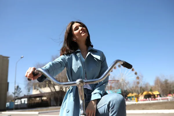 Elegante jovem mulher montando uma bicicleta . — Fotografia de Stock