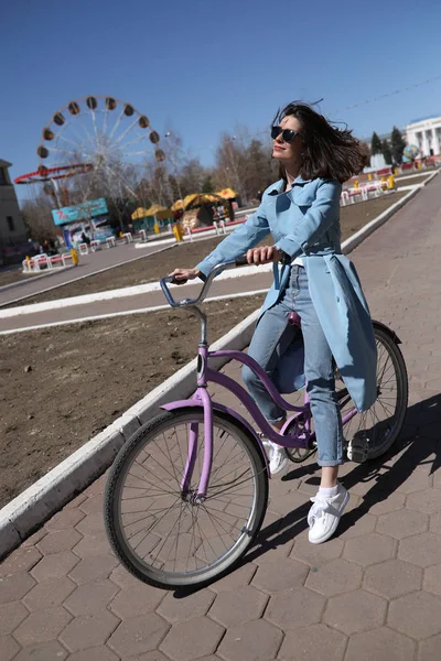 Stylish young woman riding a bicycle. — Stock Photo, Image