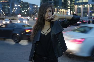 Gece şehir ve geçen arabaların arka plan üzerinde güzel kadın.