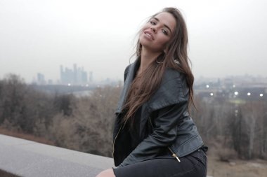 Şehir Manzaralı köprüde oturan şık genç kadın.