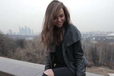 Şehir Manzaralı köprüde oturan şık genç kadın.