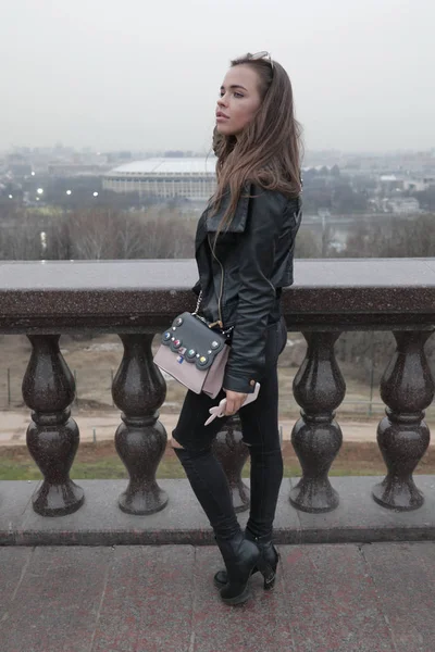 Stylish young woman walking on the city observation deck. — Stock Photo, Image