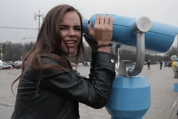 Young woman looks at the city through binoculars. — Stock Photo, Image