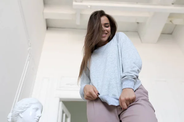 Smiling young woman in a gray sweatshirt. Mock-up.