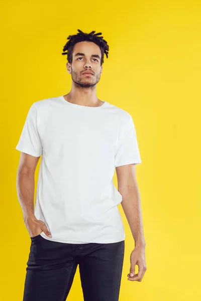 Afro-Amerikaanse man in wit t-shirt op gele achtergrond. — Stockfoto