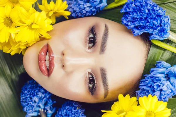 Portrait de jeune femme avec de belles fleurs bleues et jaunes autour de son visage. Printemps . — Photo