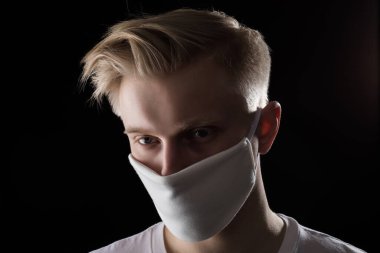 Beyaz koruyucu maskeli bir adamın portresi. COVID-19 Salgını.