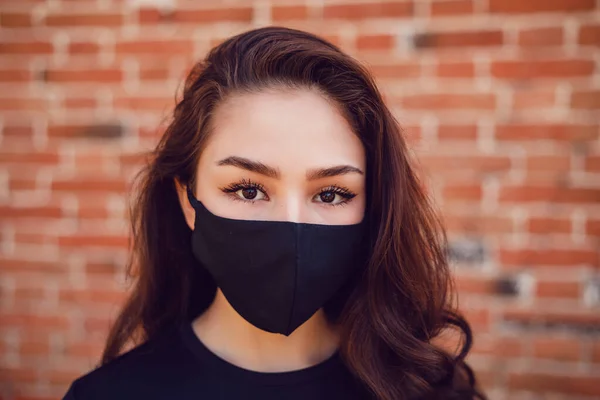 Porträtt av en ung kvinna i skyddande svart ansiktsmask. — Stockfoto