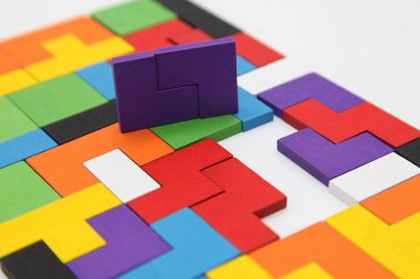 Farklı renkli şekiller tahta bloklar. Geometrik şekiller farklı renklerde. Yaratıcı, mantıklı düşünme ya da sorun çözme kavramı. Tahta zeminde geometrik şekiller. Tetris oyuncak tahta bloklar..