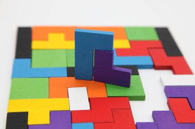 Farklı renkli şekiller tahta bloklar. Geometrik şekiller farklı renklerde. Yaratıcı, mantıklı düşünme ya da sorun çözme kavramı. Tahta zeminde geometrik şekiller. Tetris oyuncak tahta bloklar..