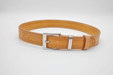 Üzerinde metal, el yapımı toka olan kahverengi deri erkek kemeri örneği. Kenarına dikilmiş. El işi konsepti, beyaz arka plan.