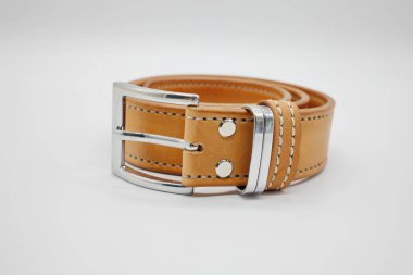 Üzerinde metal, el yapımı toka olan kahverengi deri erkek kemeri örneği. Kenarına dikilmiş. El işi konsepti, beyaz arka plan.