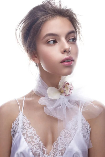 Красива дівчина в образі нареченої з квітковою орхідеєю на шиї. Модель з оголеним макіяжем і шовковою білизною . — стокове фото