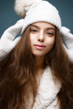Kürk pon pon ile örme beyaz şapkalı güzel kız. Nazik çıplak makyaj ile model. 