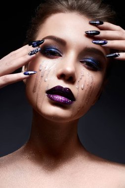 Genç ve kadın ile yaratıcı makyaj menekşe degradeyle dudakları ve yüzünde parıldıyor. Parlak tırnaklar ile rhinestones güzel model.