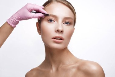 Sağlıklı cilt ve Nude makyaj ile genç kız. Güzel model kozmetik prosedürler. Koparma kaşları ve modelleme. 