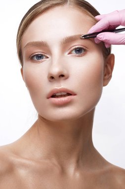 Sağlıklı cilt ve Nude makyaj ile genç kız. Güzel model kozmetik prosedürler. Koparma kaşları ve modelleme. 
