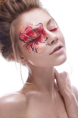Gözüne bir kırmızı-altın çiçek şeklinde yaratıcı bir makyaj ile genç bir kız. Bir bahar çiçek suretinde güzel model