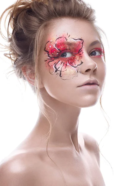 Gözüne bir kırmızı-altın çiçek şeklinde yaratıcı bir makyaj ile genç bir kız. Bir bahar çiçek suretinde güzel model