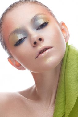 Sarı-yeşil tonlarda yaratıcı makyaj ile genç kız. Onun gözünde bir bahar çiçek görüntü üzerinde bir ışıltı ile güzel bir model